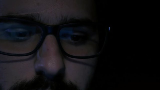 Close up reveal shot of hacker wearing glasses
