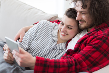 couple relaxing at  home with tablet computers