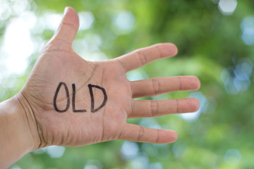 Concept Photo Of A Handwriting Word "OLD" On The Left Hand With Blurry Background