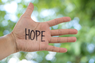 Concept Photo Of A Handwriting Word "HOPE" On The Left Hand With Blurry Background