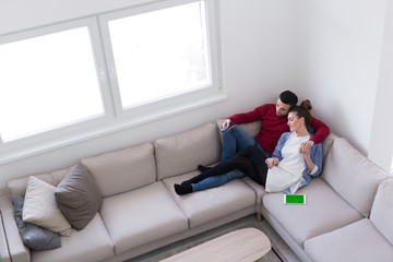 Young couple on the sofa watching television