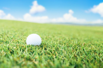 Golf ball on the grass and sky background.