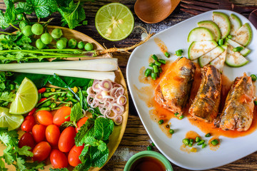 Mackerel with Tomato Sauce, Vegetables and herbs in a dish on the table. Yum Mackerel, Thai cuisine style.