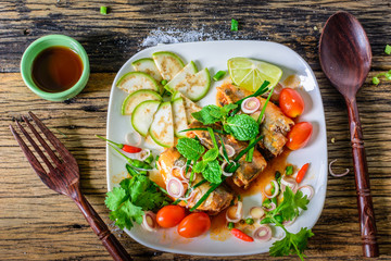 Mackerel with Tomato Sauce, Vegetables and herbs in a dish on the table. Yum Mackerel, Thai cuisine style.