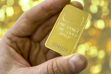 A small ingot of gold in his hand. One ounce of gold. Show gold.