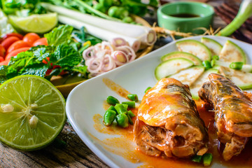 Mackerel with Tomato Sauce, Vegetables and herbs in a dish on the table. Yum Mackerel, Thai cuisine style.
