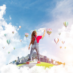 Fototapeta premium Concept of careless happy childhood with girl dreaming about future