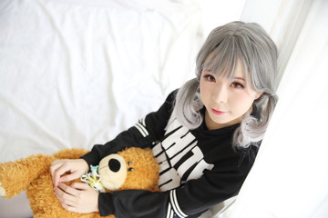 Asian young woman portrait in bed room with bear doll on white tone