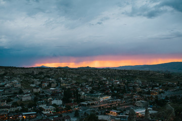 Top view. A small authentic city called Goreme in Cappadocia in Turkey in the evening. Dramatic night sky, sunset.