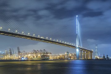 Fototapeta premium Container port and bridge in Victoria Harbor of Hong Kong city at night
