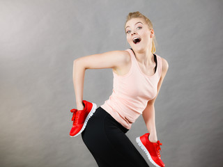 Happy woman presenting sportswear trainers shoes