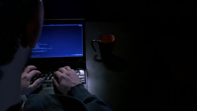 Overhead shot of hacker at his desk with mug
