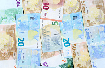 Different euro banknotes are randomly arranged.