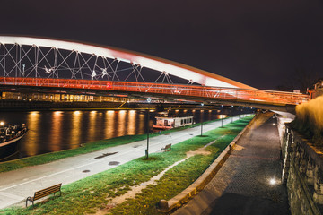 Fototapeta na wymiar Bernatka footbridge over Vistula river in the night in Krakow, Poland
