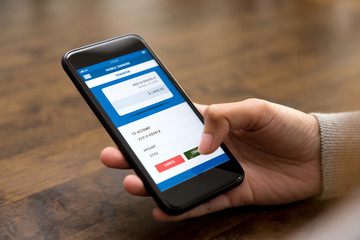 Woman hand touching confirm button on smartphone screen, transferring money online
