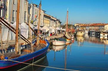 Crédence de cuisine en plexiglas Canal CESENATICO, ITALY: 01 JANUARY 2017- Christmas Fair kiosks on the embankment of the port channel with the typical fishing boats of the Adriatic Sea