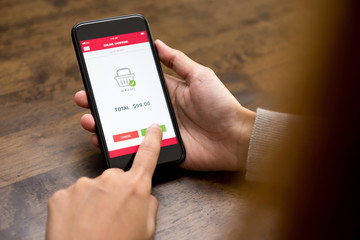 Woman hand touching button on smartphone screen, shopping online