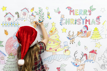 Little girl drawing Christmas pictures on a white wall © Rawpixel.com
