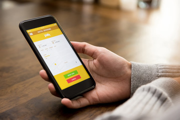 Woman booking hotel online by application on smartphone