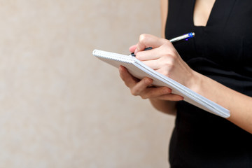 Slender girl holding a Notepad and pen
