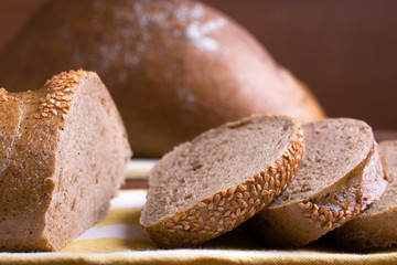 Jewish bread cut on pieces, slices on brown wooden background and fabric napkin