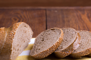 Jewish bread cut on pieces, slices on brown wooden background and fabric napkin