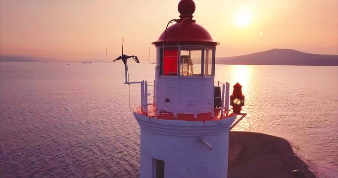 Close panoramic aerial view of old white Tokarevsky lighthouse at sunrise. Vladivostok, Russia.  It's a vantage attraction that shows where the land ends and the Pacific Ocean begins