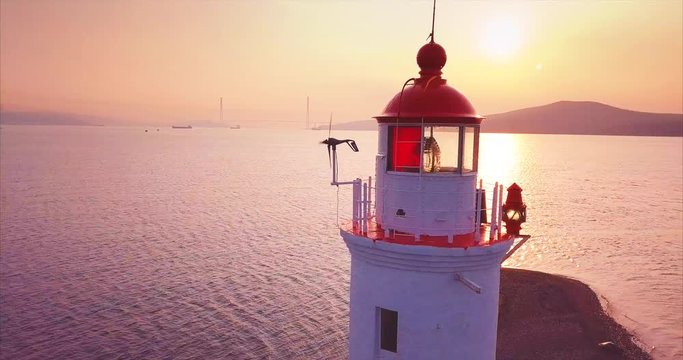 Panoramic zooming out aerial  view of old Tokarevsky lighthouse at amazing sunrise. Vladivostok, Russia.  It's a vantage attraction that shows where the land ends and the Pacific Ocean begins