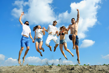 Image of young people jumping together outdoor.