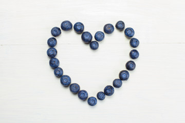 BLUEBERRIES HEART SHAPED WHITE WOOD BACKGROUND