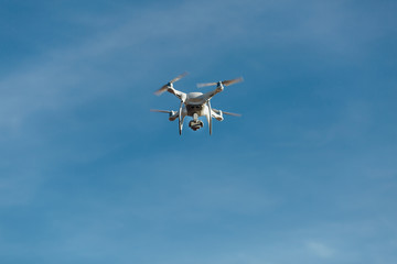 drone, helicopter, quadrupter flies against the blue sky. A high-definition camera shoots photos.