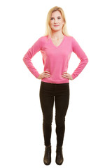 Junge blonde Frau frontal mit Händen in der Hüfte