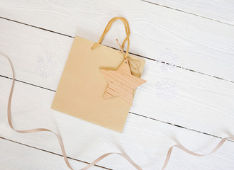 Mockup Paper bag from kraft paper with gift tag star and on a wooden background. Flat lay, top view...