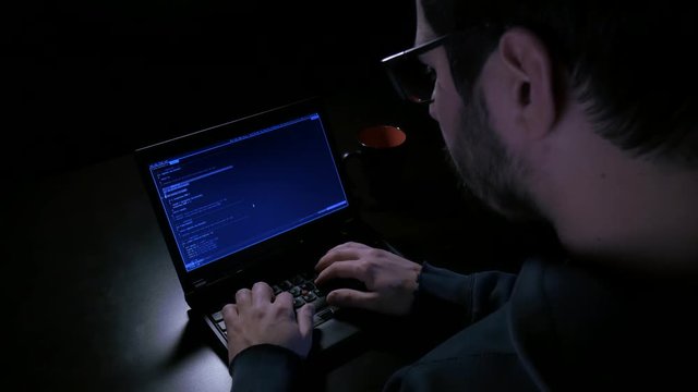 Overhead shot of hacker working with glasses
