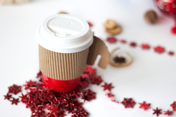 A paper cup of coffee, peppermint mocha, displayed with christmas decorations on white background