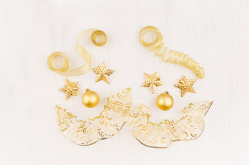 Fun face clowns of gold stars, balls, curl ribbons on soft white wood board. Christmas, festive, circus background.