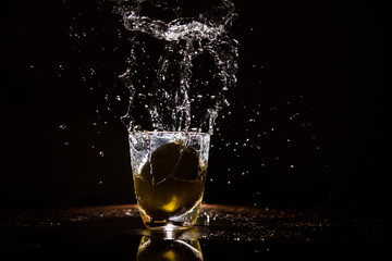 Lemon dropped in a glass of watter and frozen with a flash