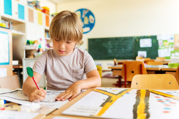 Cute little boy working in classroom, education, back to school concept