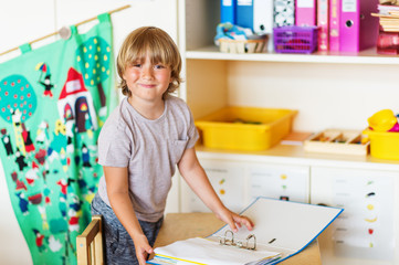 Cute little boy working in classroom, education, back to school concept