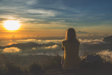 Girl watching the sunrise from mount Batur, Bali - Indonesia.