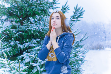 The girl in the snow thinks of the desire to believe in miracles and prays to God for the welfare and fulfillment of the miracle at Christmas.