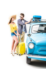 couple putting luggage on car roof