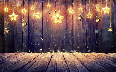 Glowing Christmas Stars Hanging At Rustic Wooden Background
