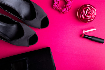 Fashion Lady Accessories Set. Black and pink. Minimal. Black Shoes, bracelet, perfume, lipstick and bag on pink background. Flat lay.