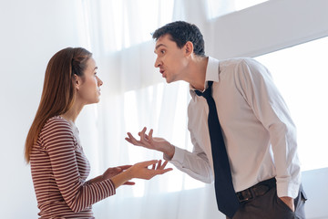 Misunderstanding. Emotional angry irritated man looking expressive while explaining his point of view to his upset wife