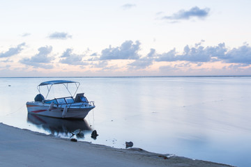 Boat floating in sea at the beach,Colorful sunset with boat ot the river bank.