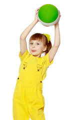 Girl with a short bangs on her head and bright yellow overalls.