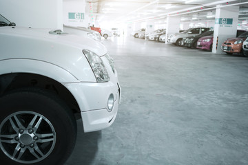 Many cars in parking garage interior, industrial building