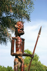 Painted wooden idol with a spear