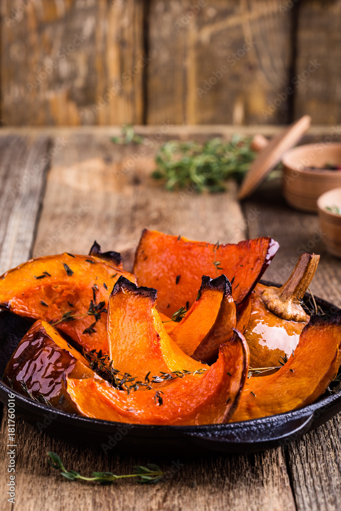 Wall mural Baked pumpkin with thyme in cast iron skillet